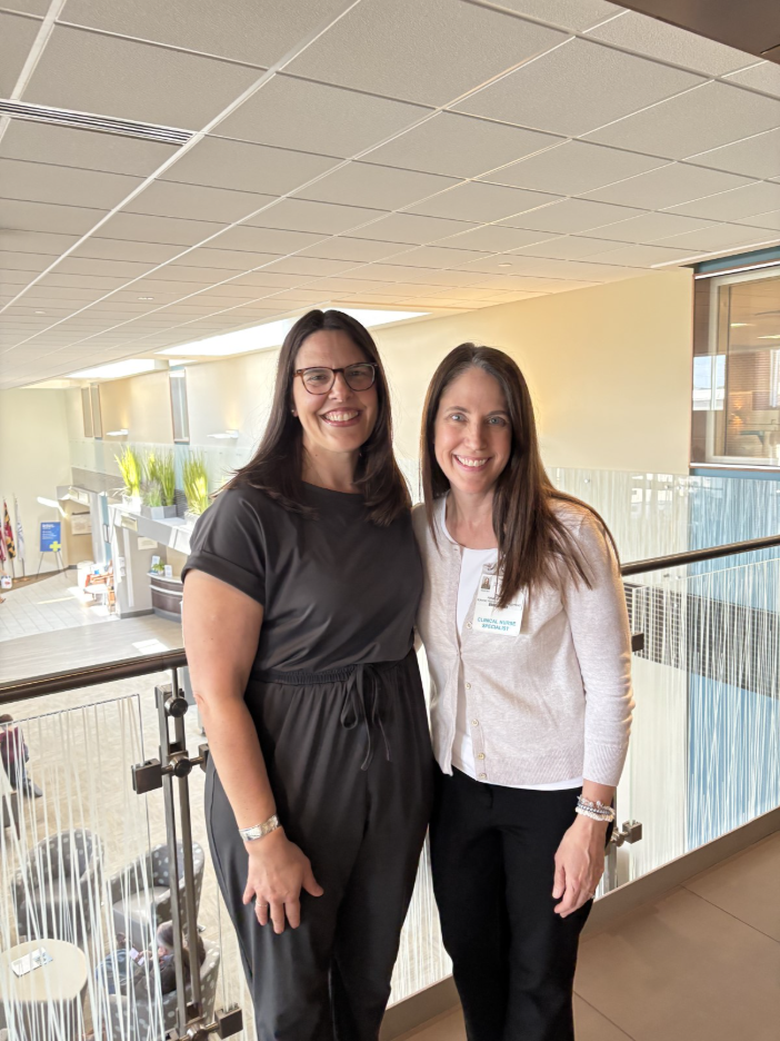 Two nurses stand in Frederick Health hospital lobby