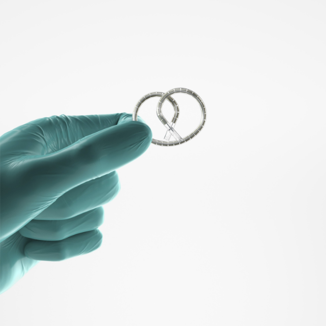 a gloved hand holds the pretzel-shaped intravesical system