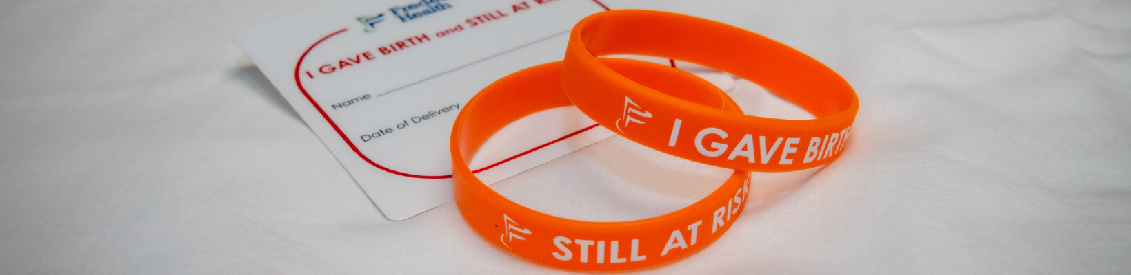 Orange bracelets that say "I gave birth" and "Still at risk" for Frederick Health birth patients