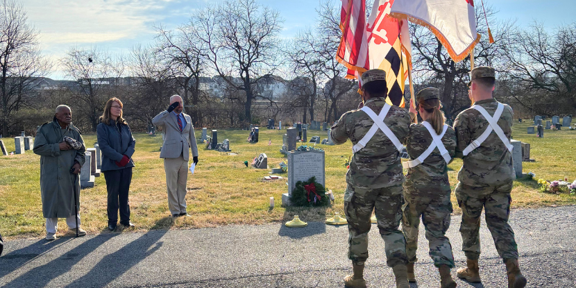 Frederick Health CEO Dr. Cheryl Cioffi and COO Mike McLane stand beside caretaker Bernard Brown as Hood College ROTC Color Guard approach with flags to kick-off the Wreaths Across America event