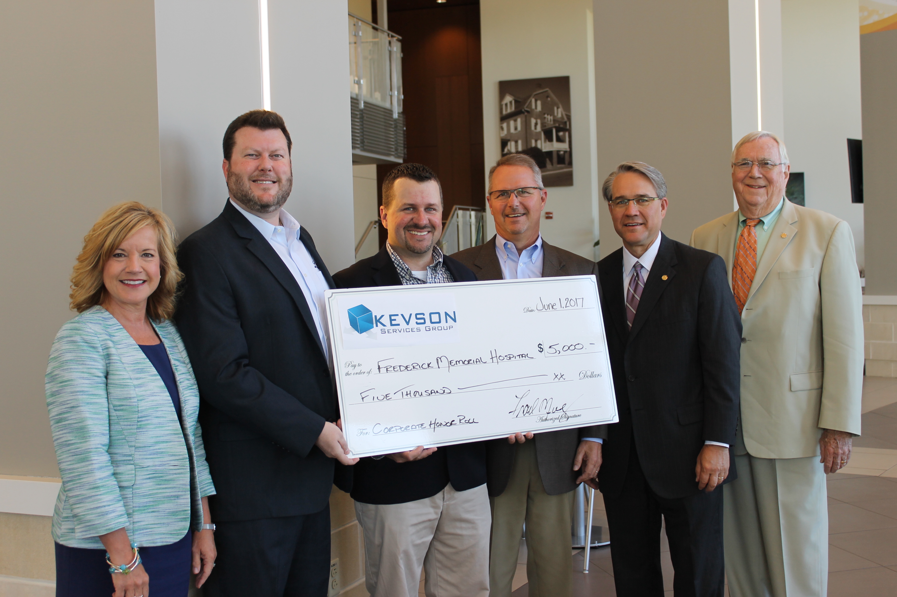 group of people holding a large check