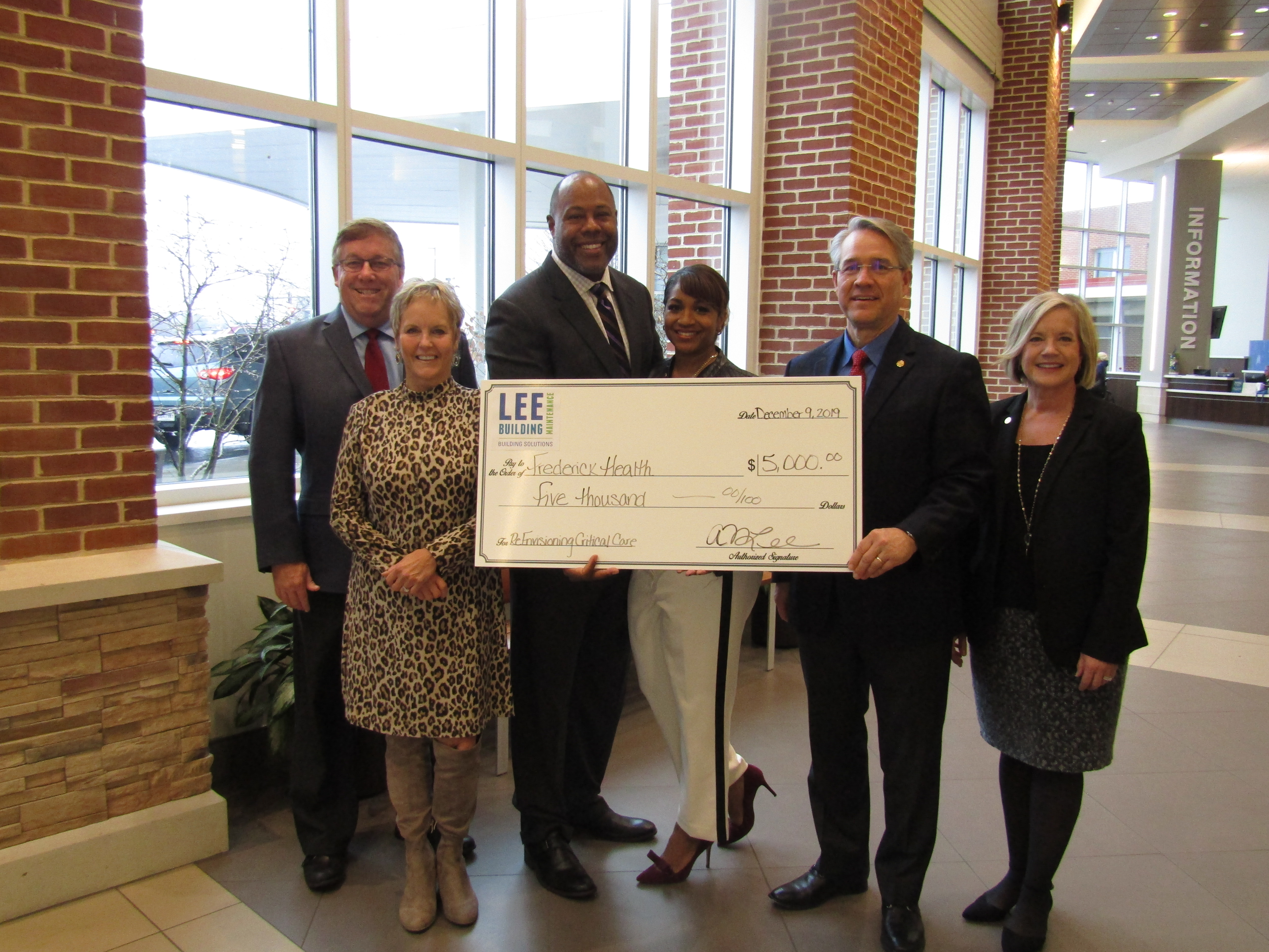 group of people holding a check