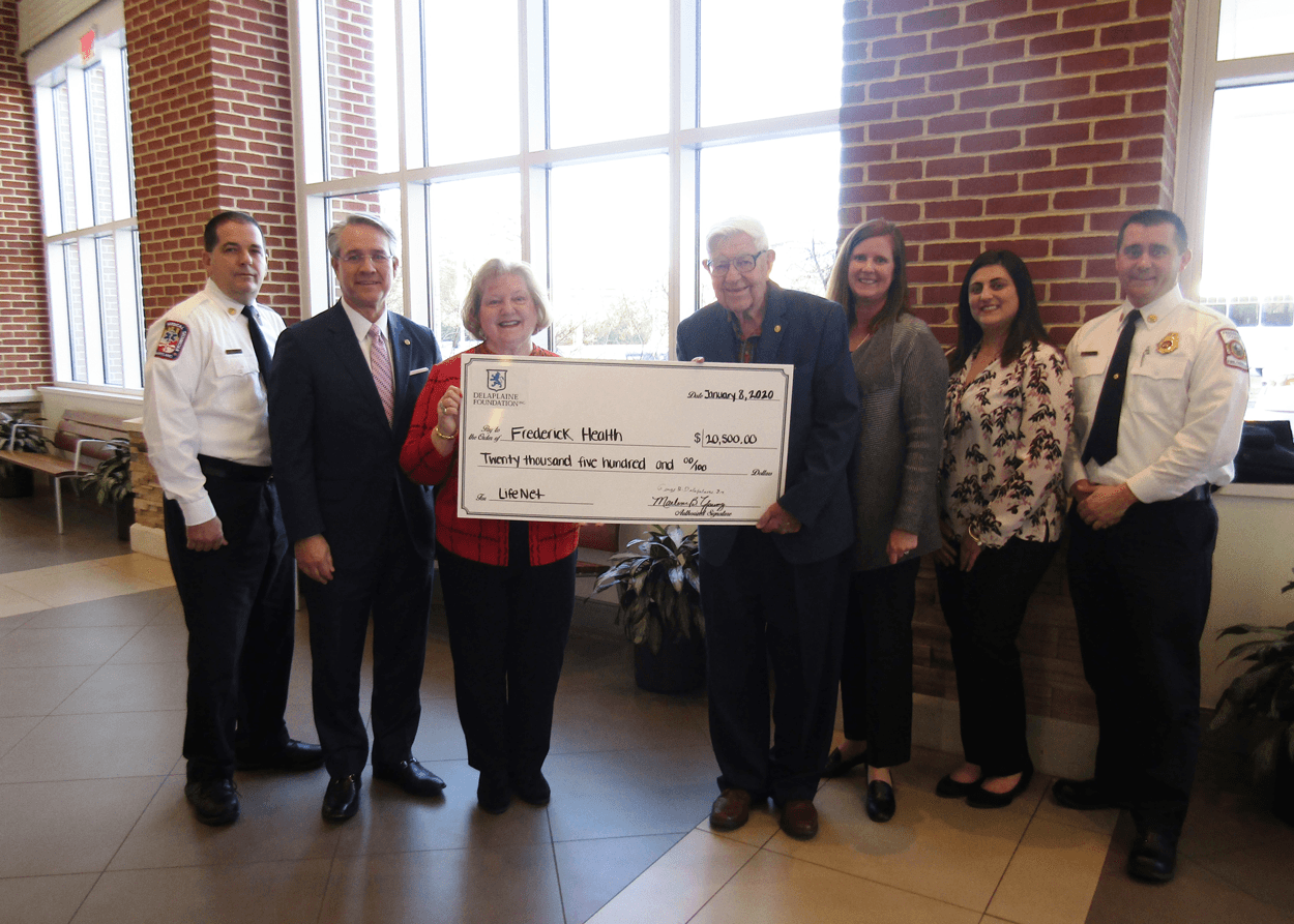 group of people holding a giant check