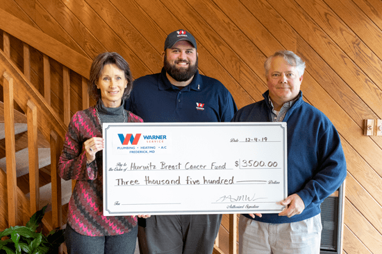 group of people holding a giant check